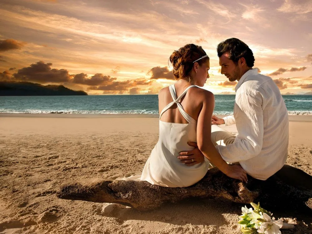 парень и девушка сидят возле моря